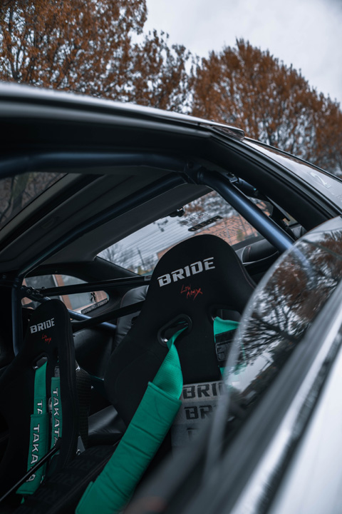 Interior detail of Aum Sung’s 1992 Lexus SC400 featuring Bride racing seats, Takata harnesses, and a Cusco roll cage.