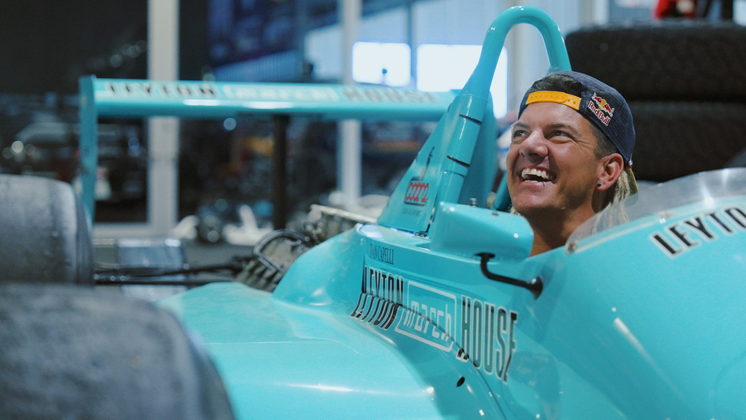 Driver smiling from inside the teal March Formula One chassis during the FORMIDABUL drift car project.