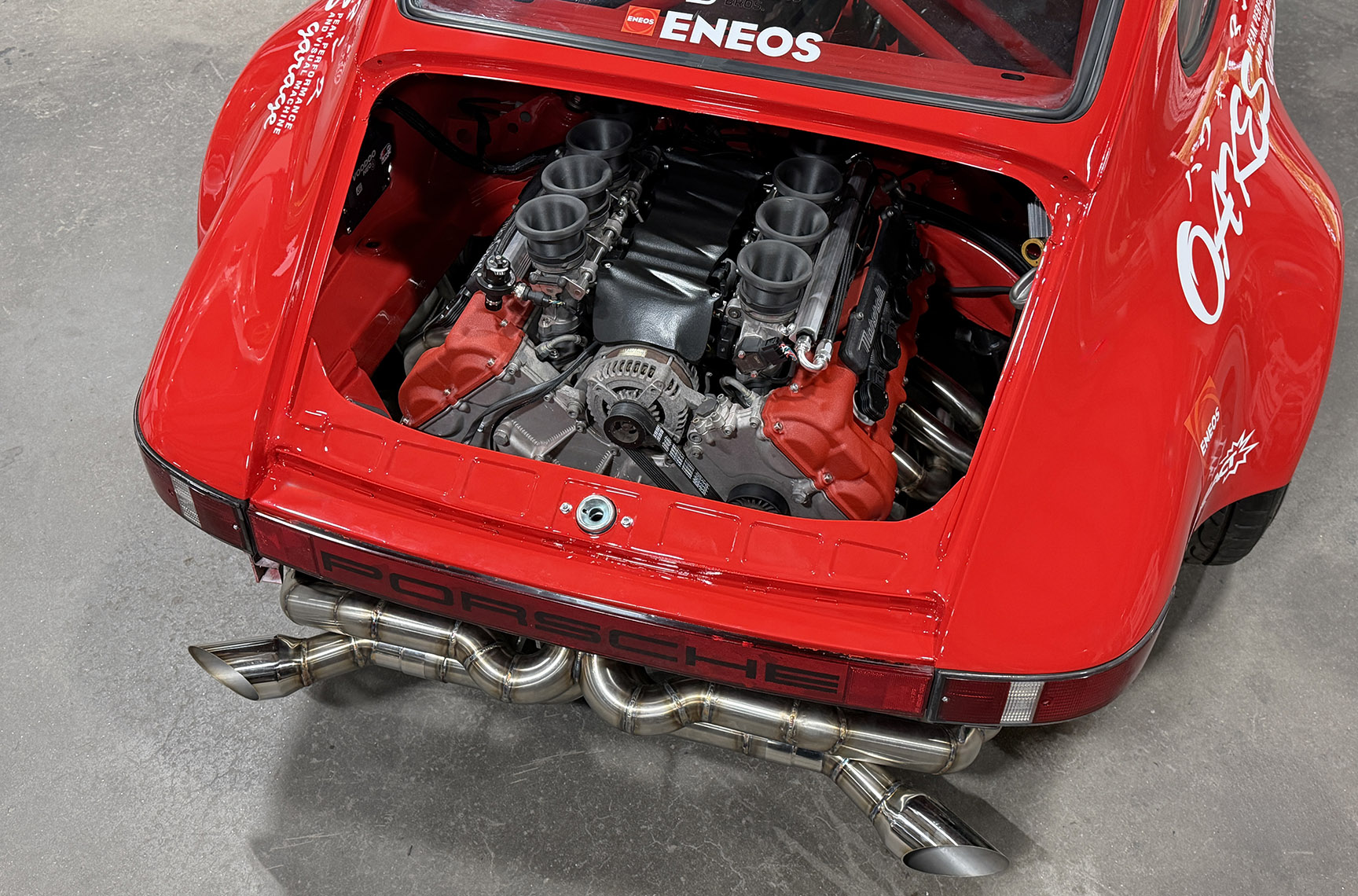 Close-up of the Ferrari-built Maserati F136 V8 engine installed in Jimmy Oakes’ Porsche 911 SC Porrari with custom exhaust and ENEOS livery.