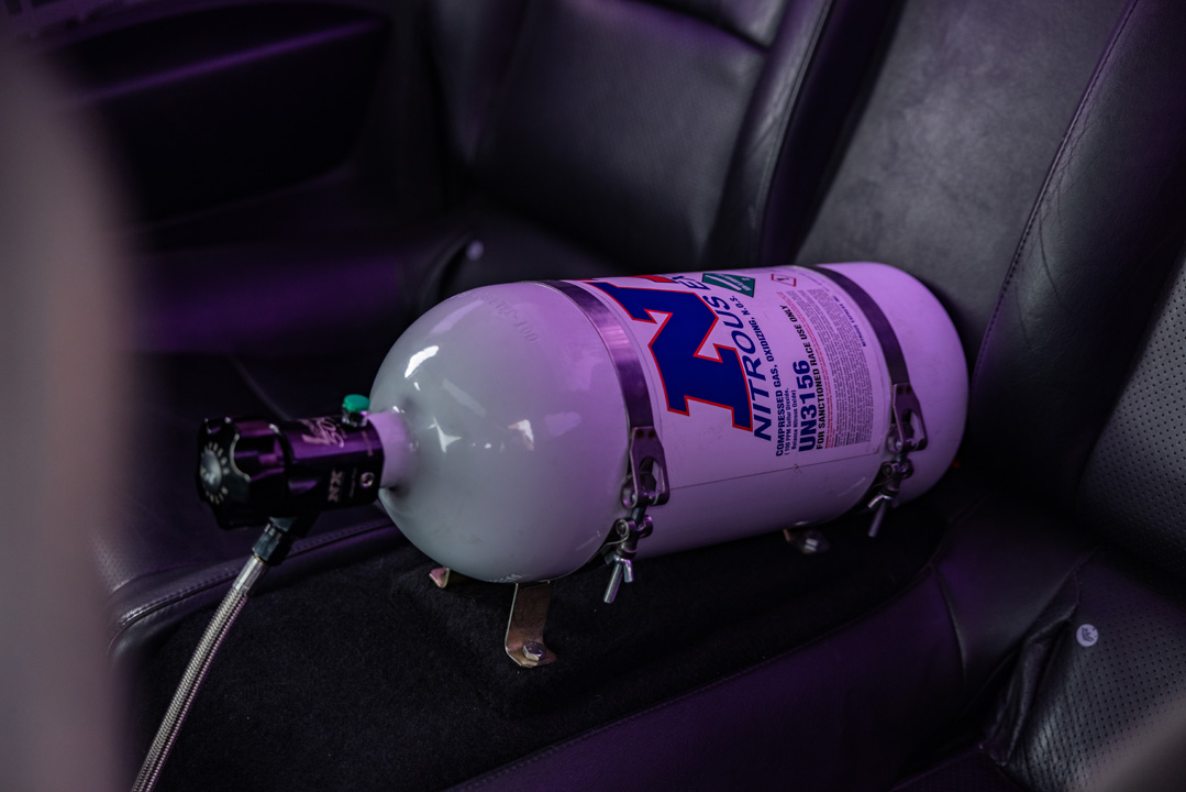 Interior detail of Jordyn Brazeau’s 2006 Infiniti G35 showing the Nitrous Express bottle mounted behind the front seats.