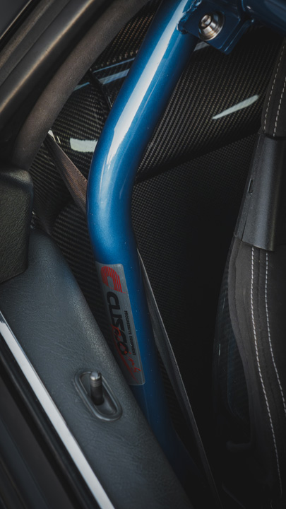 Interior detail of Peter Doan’s 1991 Honda NSX showing the Hybrid Racing shifter, carbon center console, and right-hand-drive cockpit.