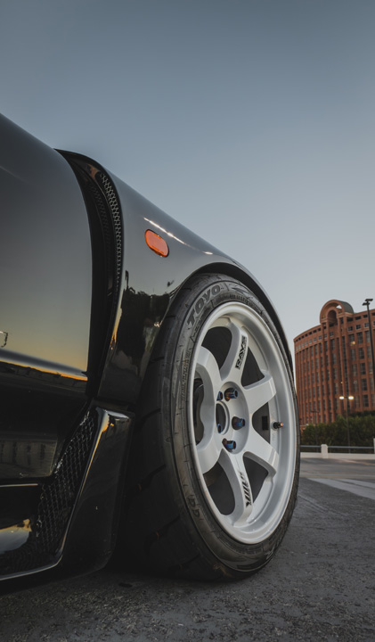 Close-up of Peter Doan’s black 1991 Honda NSX showing the white Volk Racing TE37 wheel, Toyo tire, front fender, and side intake detail.