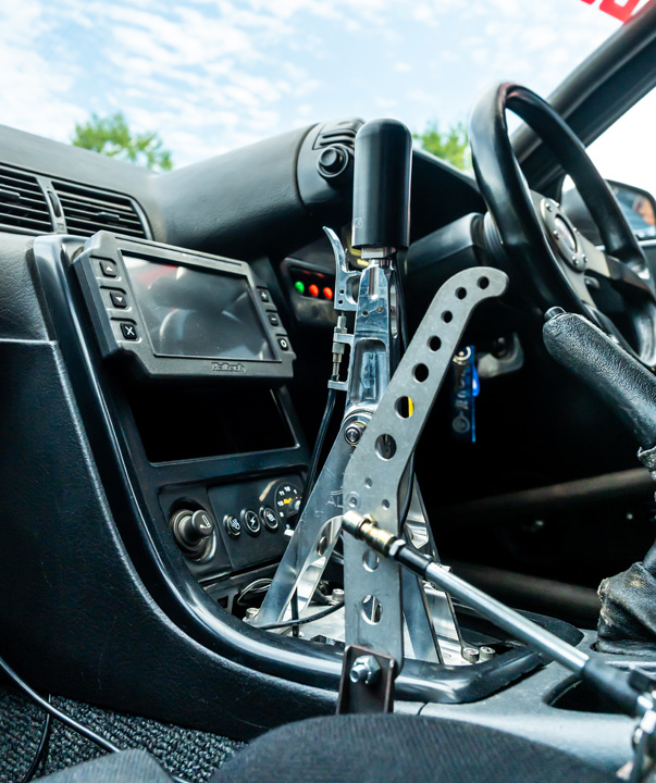 Interior detail of Cee Vann’s 1990 Nissan Skyline GT-R showing the Albins sequential shifter setup, Haltech display, and right-hand-drive cockpit.