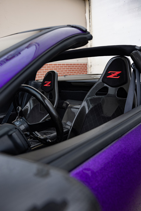 Interior detail of Alex Hammond’s 1993 Nissan 300ZX Convertible showing the carbon-fiber seats with red Z logos, convertible cabin, and custom trim.