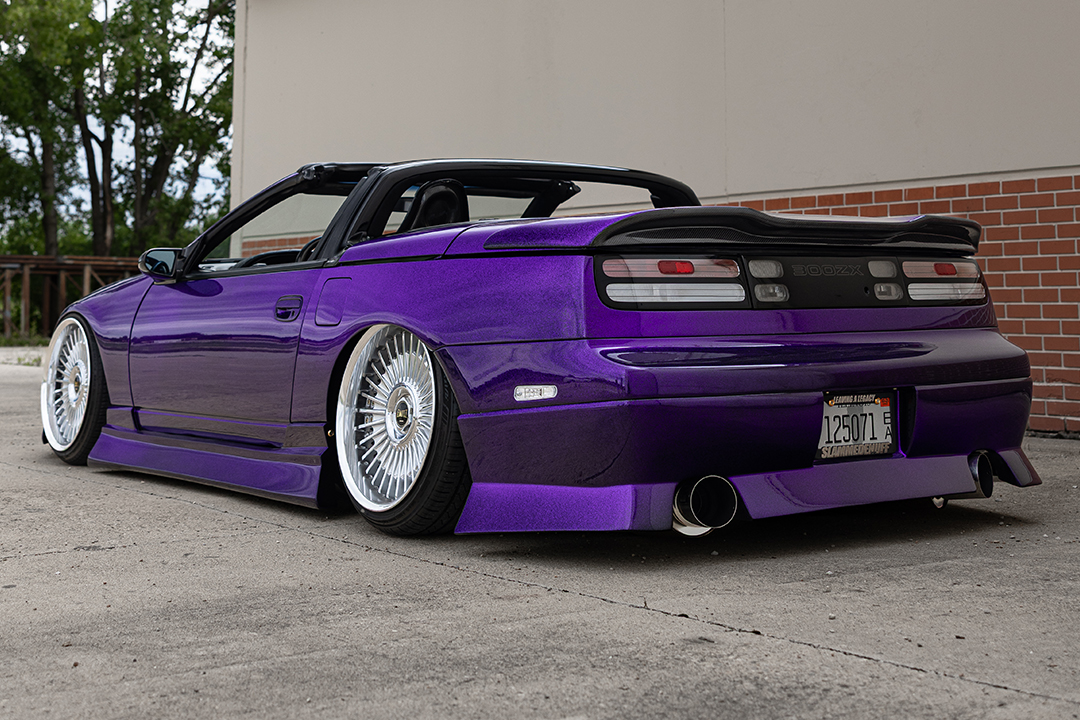 Rear three-quarter view of Alex Hammond’s purple 1993 Nissan 300ZX Convertible showing the low stance, polished wheels, custom rear bumper, and carbon spoiler.