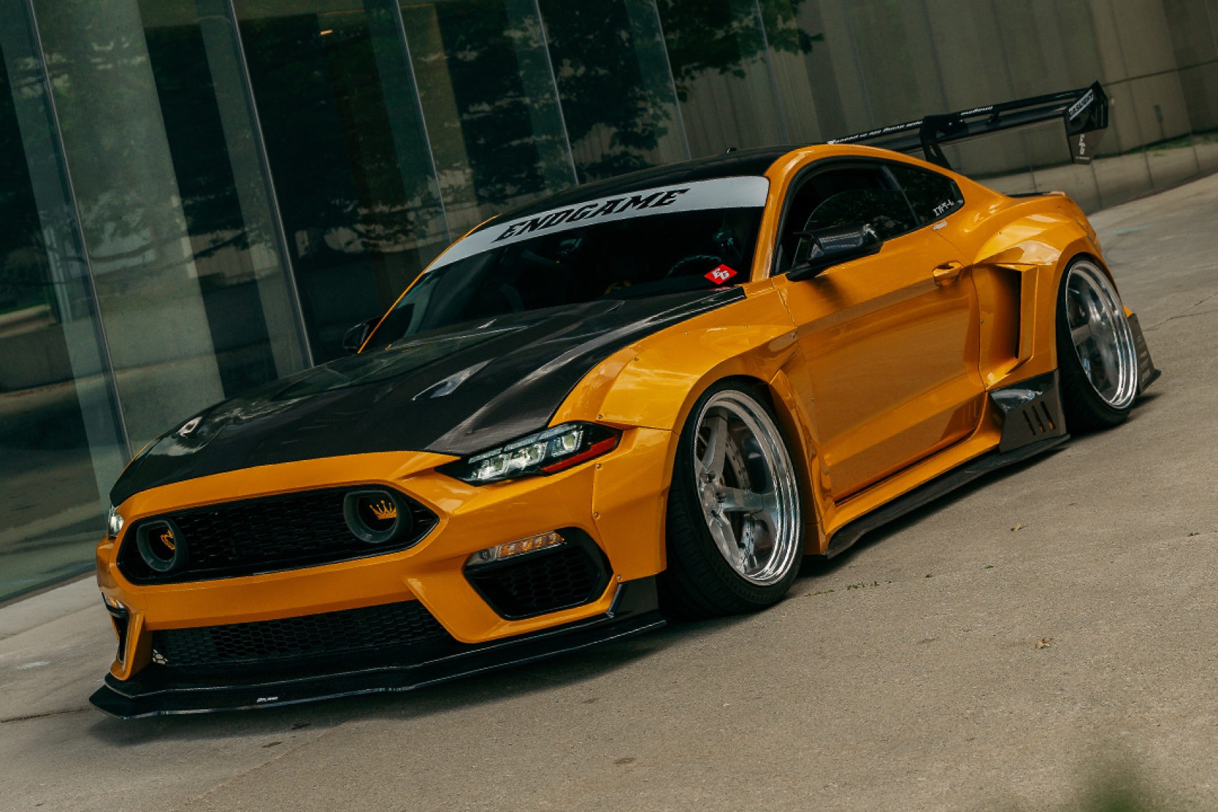 Mussi Hussain’s Cyber Orange 2022 Ford Mustang GT with Robot Craftsman widebody aero, carbon hood, Mach 1 front-end conversion, Work Gnosis wheels, and large rear wing.