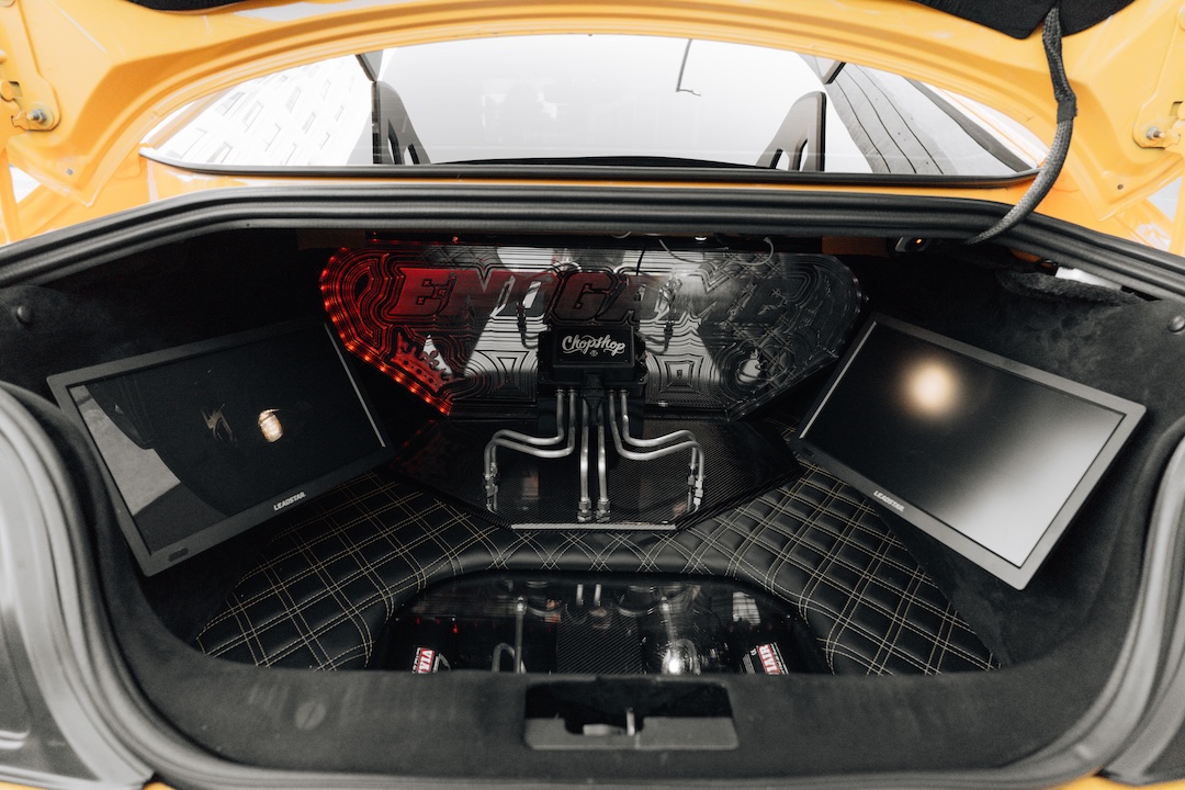 Mussi Hussain’s Cyber Orange 2022 Ford Mustang GT with Robot Craftsman widebody aero, Air Lift suspension, Work Gnosis wheels, custom lighting, carbon-fiber details, and reworked interior and trunk setup.