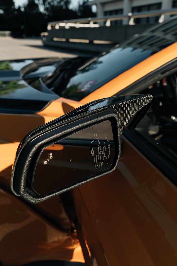 Mussi Hussain’s Cyber Orange 2022 Ford Mustang GT with Robot Craftsman widebody aero, Air Lift suspension, Work Gnosis wheels, custom lighting, carbon-fiber details, and reworked interior and trunk setup.