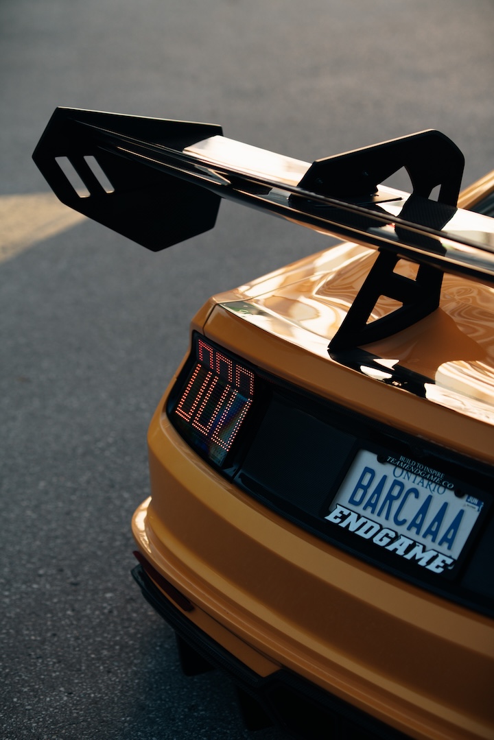 Mussi Hussain’s Cyber Orange 2022 Ford Mustang GT with Robot Craftsman widebody aero, Air Lift suspension, Work Gnosis wheels, custom lighting, carbon-fiber details, and reworked interior and trunk setup.