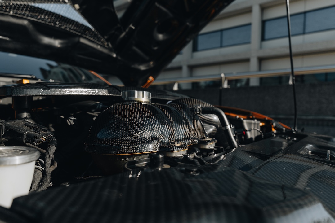 Mussi Hussain’s Cyber Orange 2022 Ford Mustang GT with Robot Craftsman widebody aero, Air Lift suspension, Work Gnosis wheels, custom lighting, carbon-fiber details, and reworked interior and trunk setup.