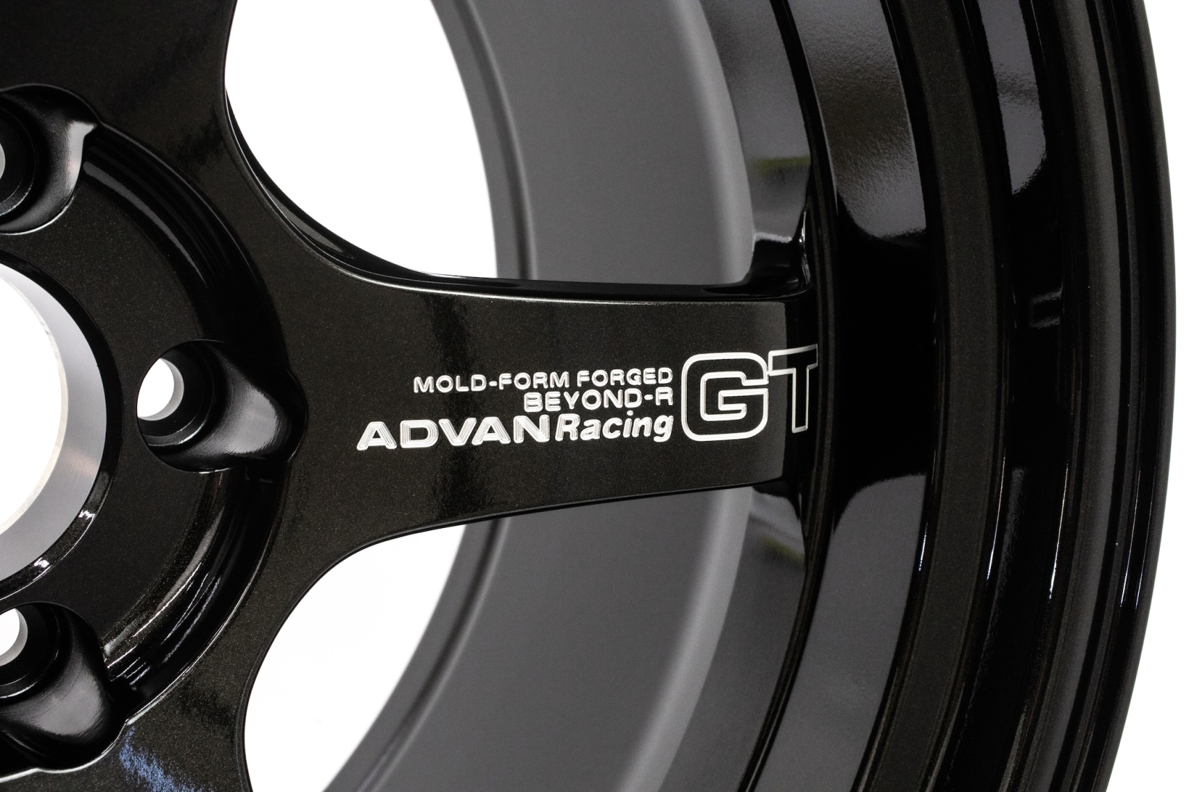 Close-up of the ADVAN Racing GT BEYOND-R forged wheel showing the spoke branding, stepped rim profile, and Racing Titanium Black finish.