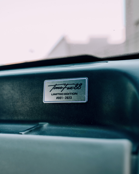 Regan McLaughlin’s 1988 Ford Mustang GT TimeFox with custom multi-tone paint, Ford Barra turbo swap, wide fiberglass fenders, retro Foxbody styling, HaloBLK wheel covers, custom interior, and nostalgic audio details.