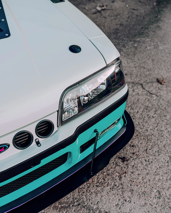 Regan McLaughlin’s 1988 Ford Mustang GT TimeFox with custom multi-tone paint, Ford Barra turbo swap, wide fiberglass fenders, retro Foxbody styling, HaloBLK wheel covers, custom interior, and nostalgic audio details.
