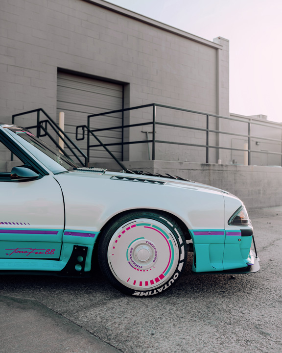 Regan McLaughlin’s 1988 Ford Mustang GT TimeFox with custom multi-tone paint, Ford Barra turbo swap, wide fiberglass fenders, retro Foxbody styling, HaloBLK wheel covers, custom interior, and nostalgic audio details.