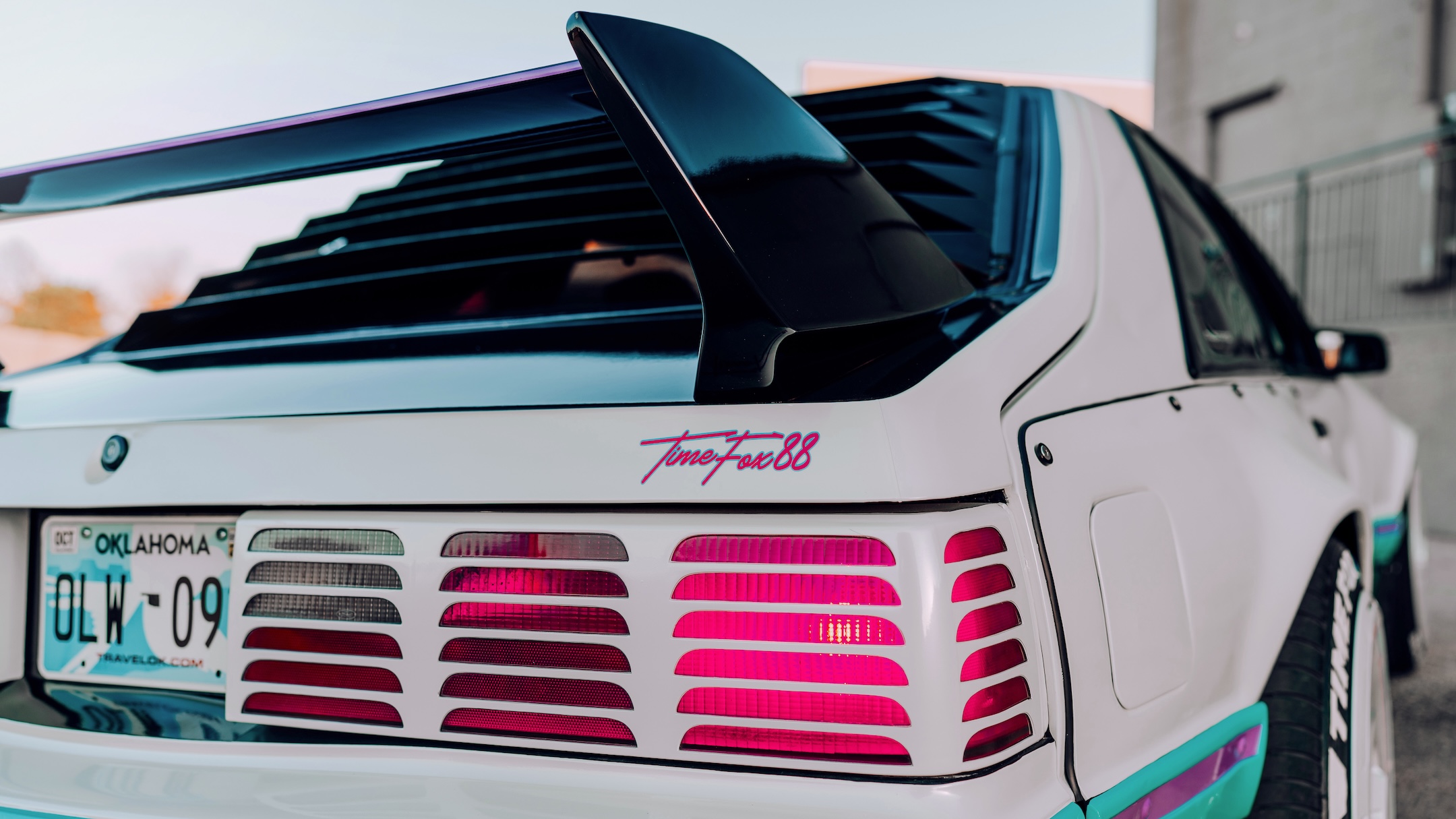 Rear detail of Regan McLaughlin’s 1988 Ford Mustang GT TimeFox showing the Evo-style rear wing, Mustang rear window vents, custom taillight treatment, TimeFox88 script, and retro Foxbody styling.