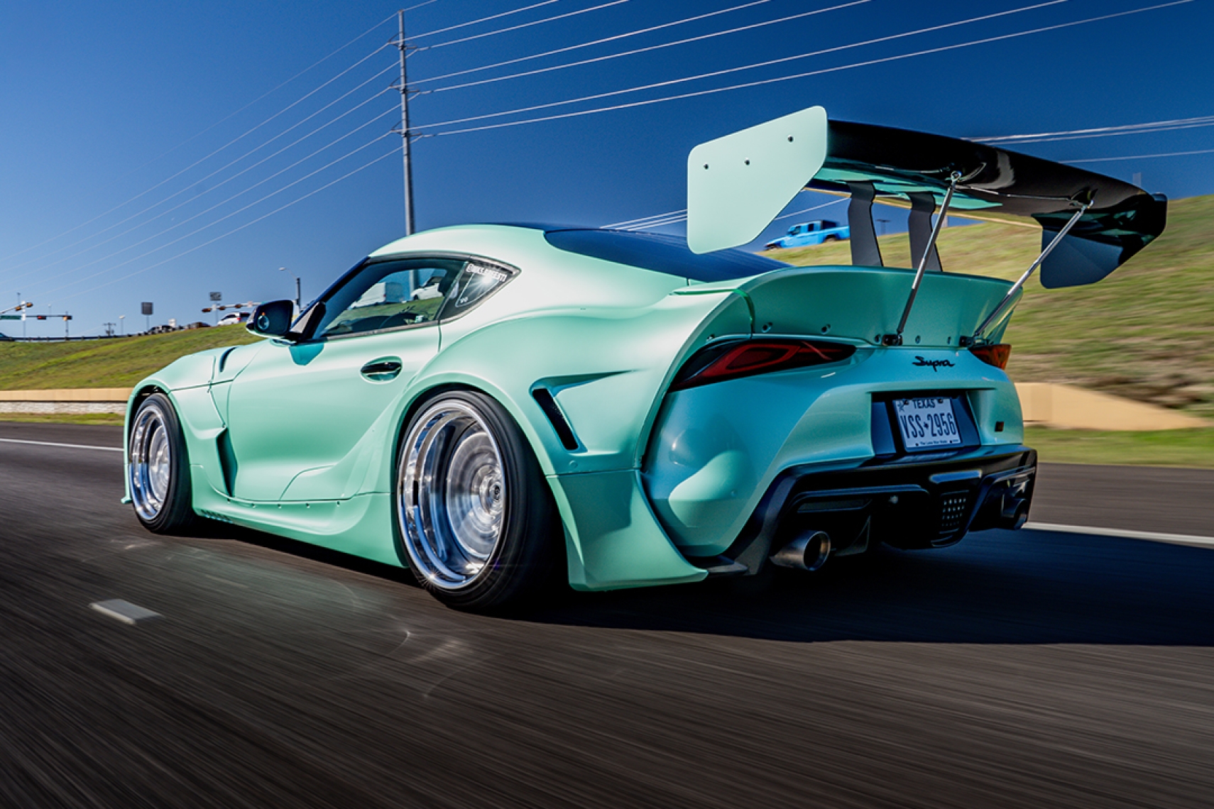 Bryan Miguel’s 2021 Toyota GR Supra with Pandem widebody in a rear three-quarter rolling shot.