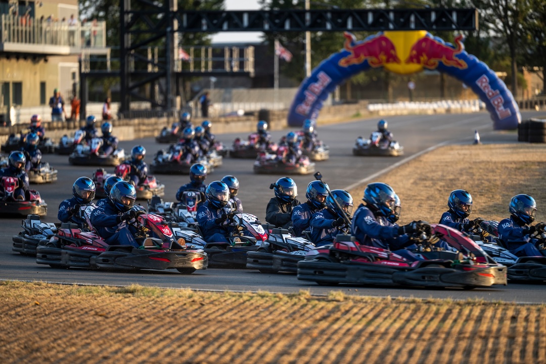 Drivers race in a large go-kart field during testing for Red Bull Max vs 100 at Silverstone Circuit.