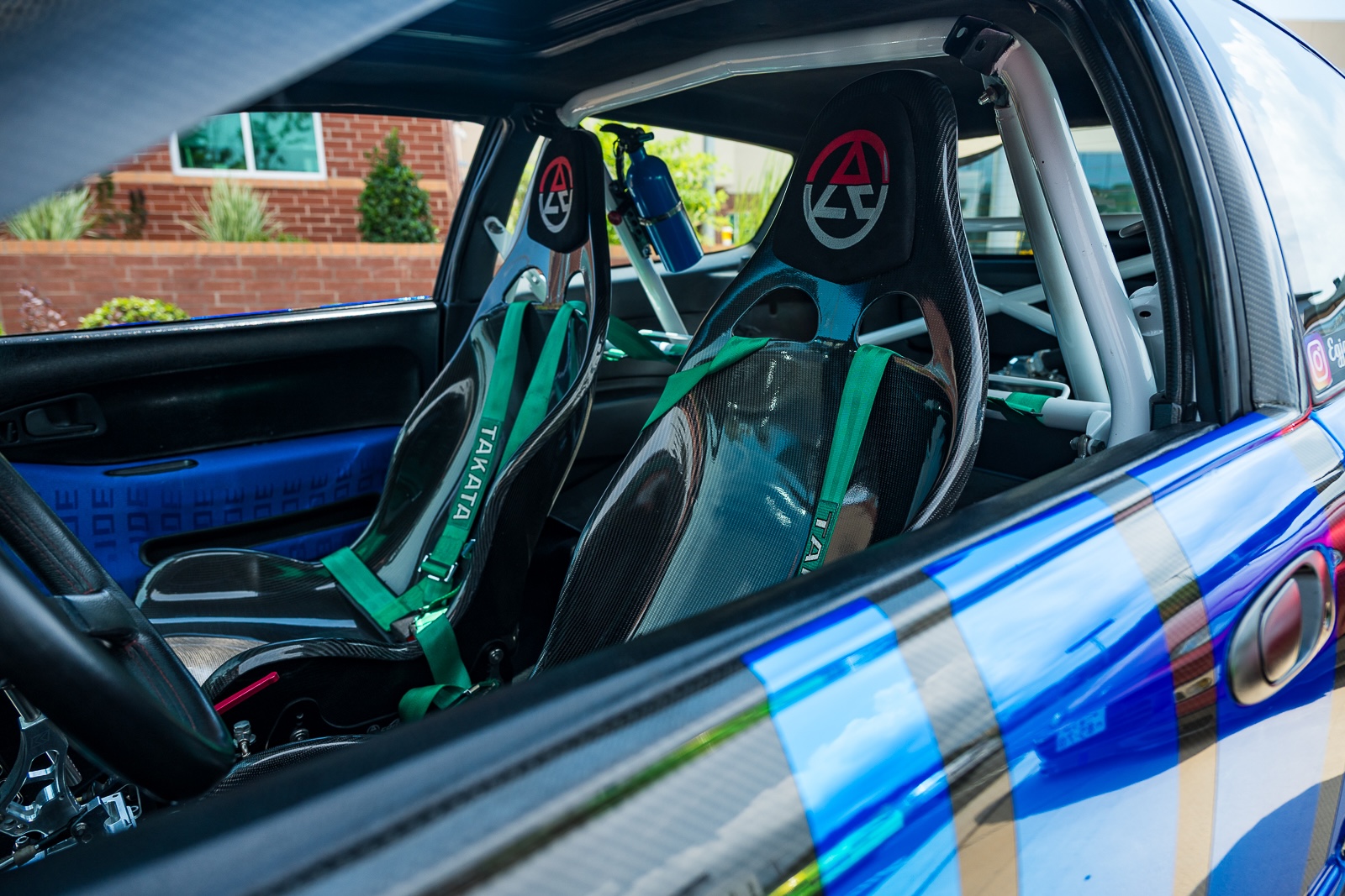 Carbon fiber racing seats, Takata harnesses and roll cage inside the Honda Civic at Daikoku Tensei Style 2026.