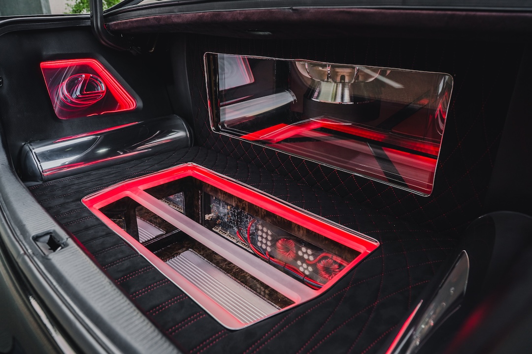 Custom trunk of Kyle Harty’s 1999 Lexus GS 400 showing its upholstered audio installation, amplifiers, subwoofer, and illuminated display panels.