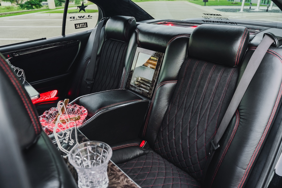 Rear interior of Kyle Harty’s 1999 Lexus GS 400 showing its custom leather upholstery, handmade VIP tray table, and custom rear console.