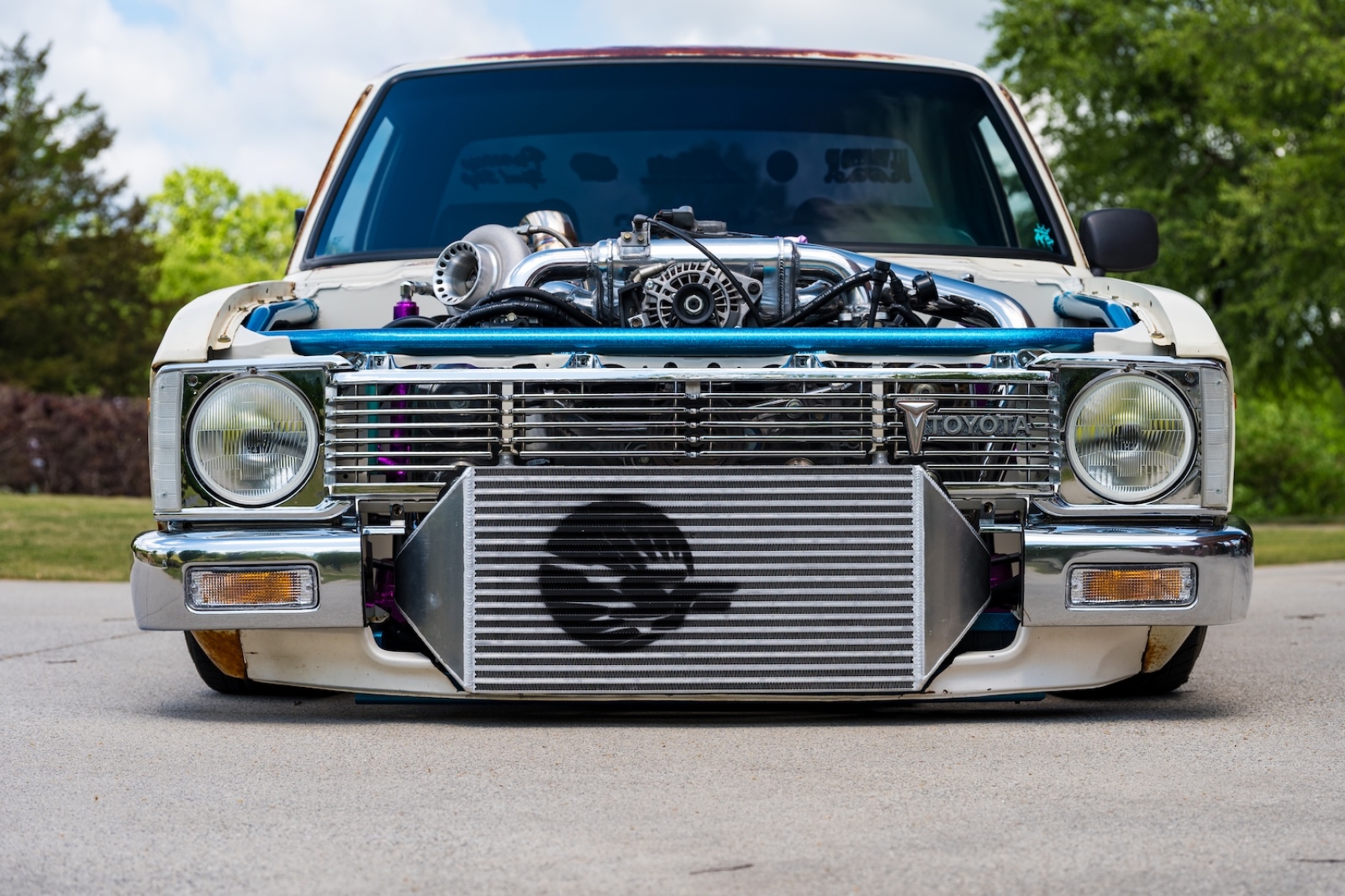 Front view of Amanda Livingston’s 1979 Toyota Pickup showing its exposed turbocharged Subaru WRX engine and front-mount intercooler.