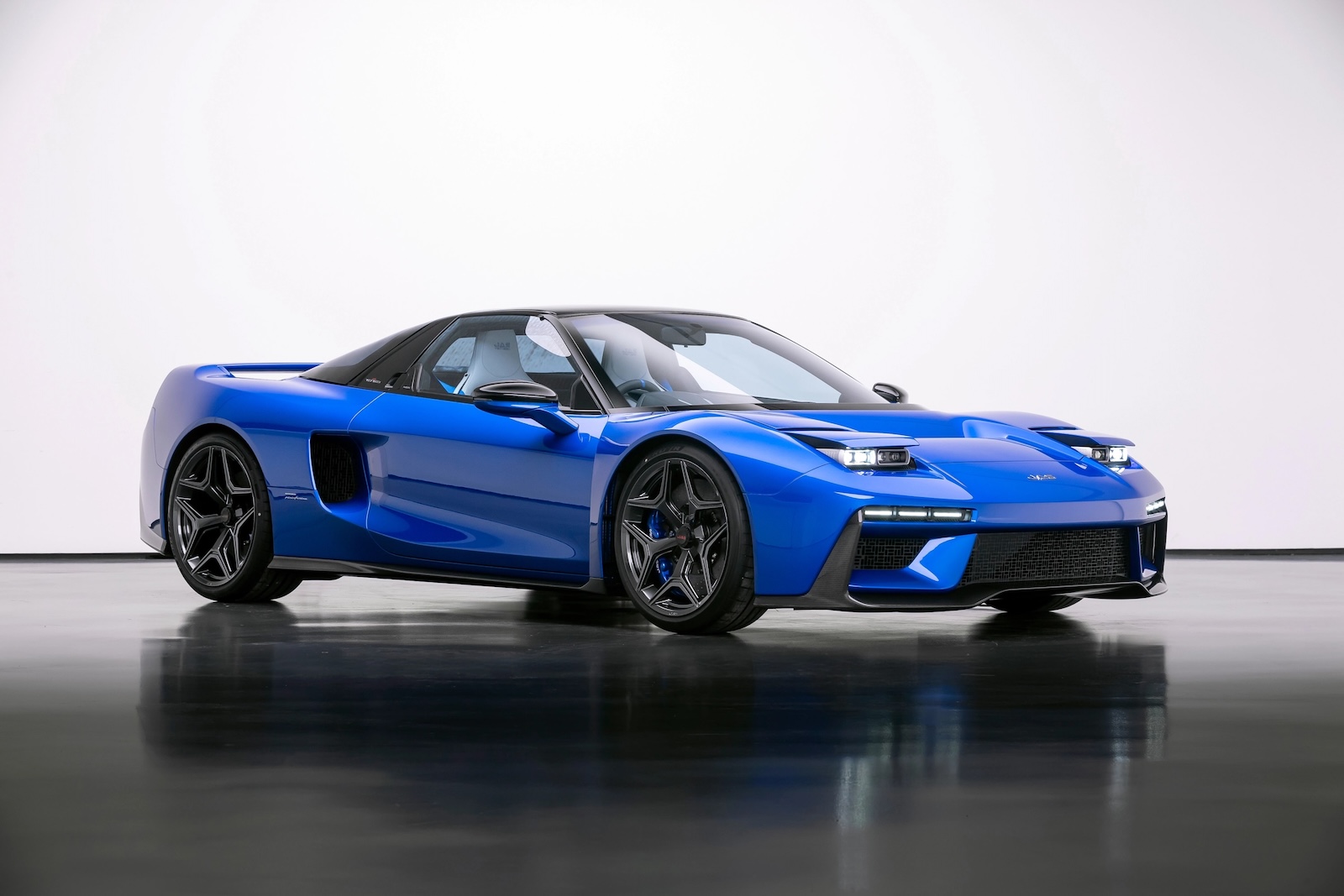 Front three-quarter view of the blue JAS Tensei Honda NSX restomod, showcasing Pininfarina's redesigned bodywork, pop-up-style headlights and forged wheels.
