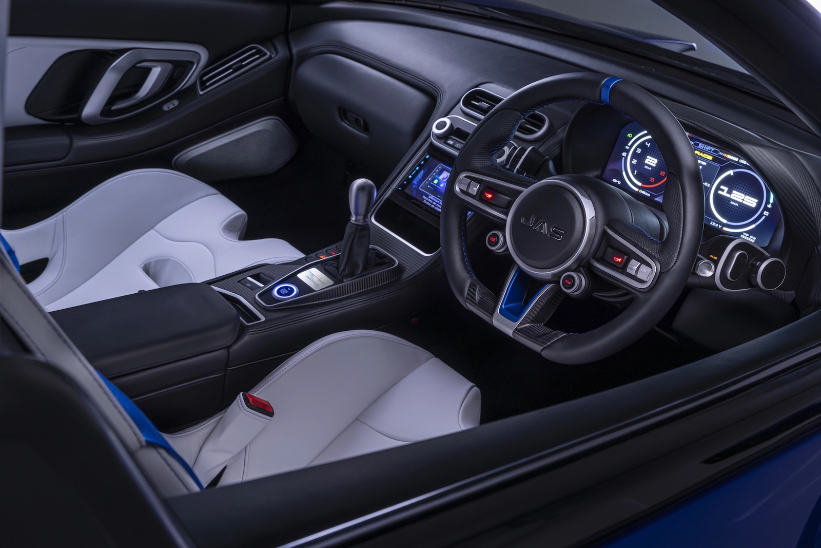 Interior of the JAS Tensei Honda NSX featuring a redesigned right-hand-drive cockpit, digital instrument cluster, manual shifter, carbon-fibre trim and white sport seats.