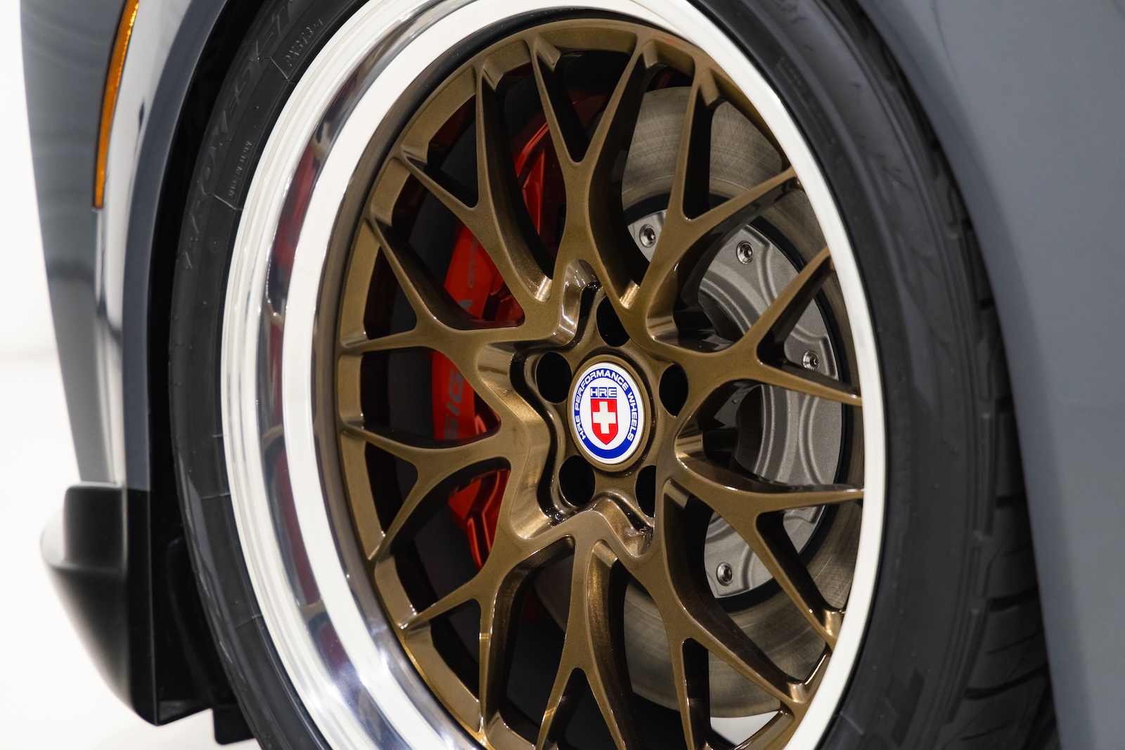 Close-up of the Toyota Crown Signia GT-S Concept's bronze 21-inch HRE multi-spoke wheel with polished lip, red brake caliper and performance tire.