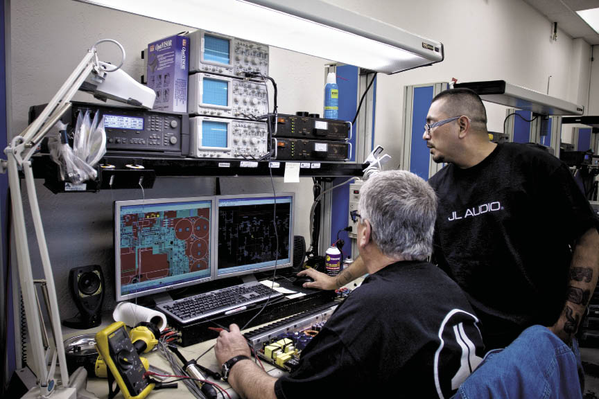 Nearing the last stages of production of a W7 subwoofer. Here, a specially built device lifts and flips the woofer so the operator can finish the assembly.